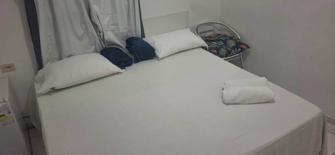 Quarto preparado com enxoval claro e camas confortáveis